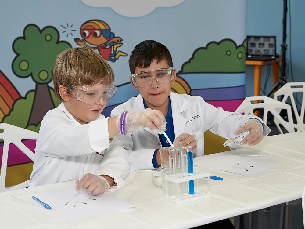 two boys sitting at white table