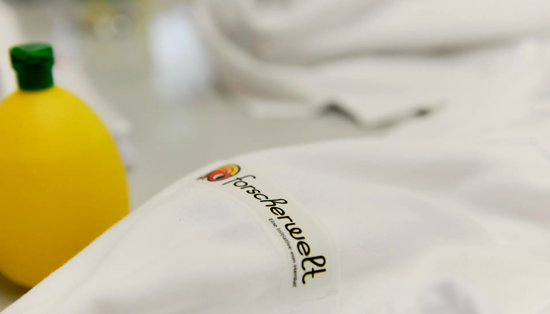 zbliżenie fartucha laboratoryjnego z logo Forscherwelt