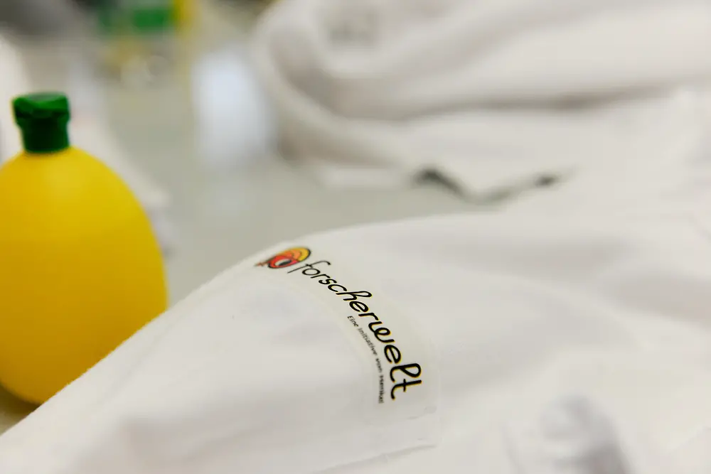 close up of lab coat with Forscherwelt logo
