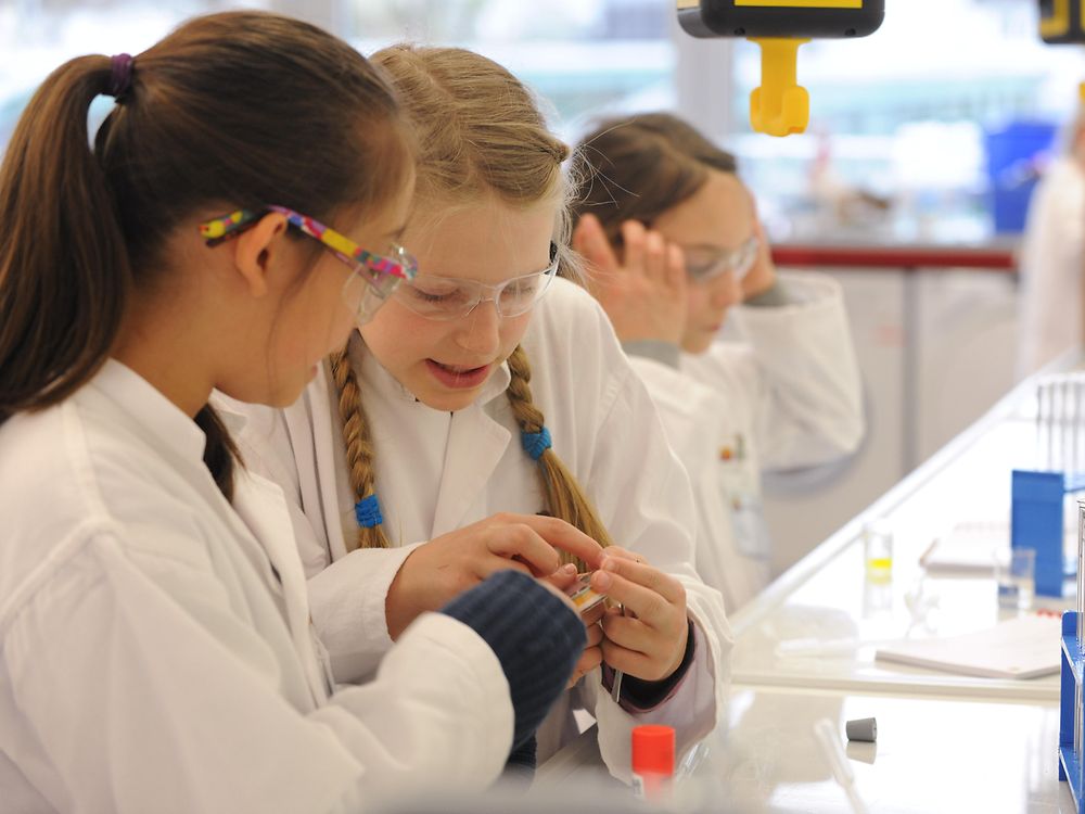 dwie dziewczyny w fartuchach laboratoryjnych na ławce