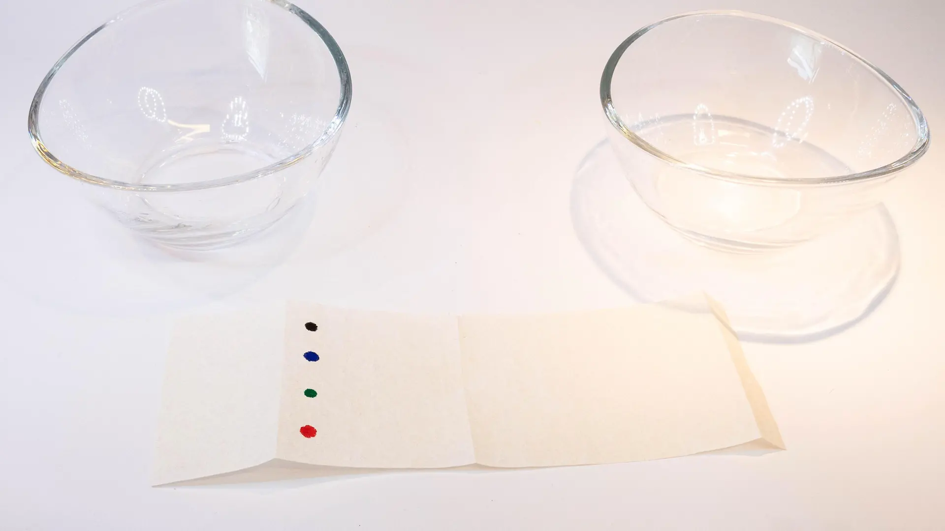 tira de papel con puntos coloridos frente a dos tazones de vidrio