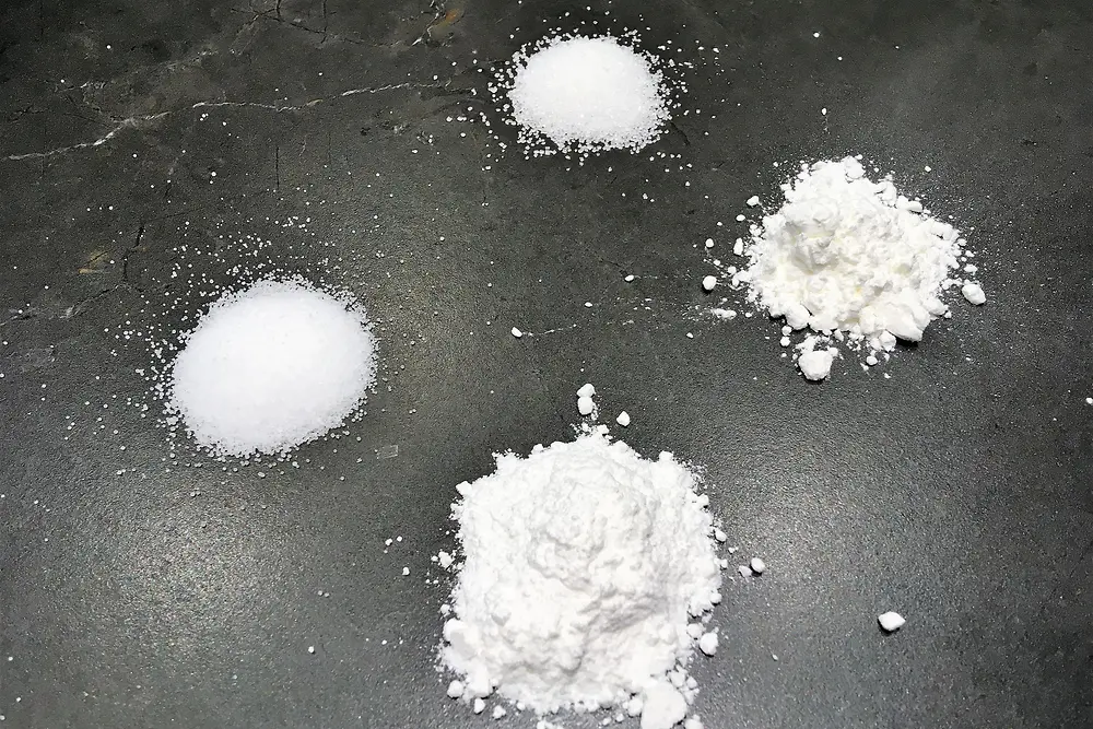 4 weiße Pulver auf schwarzem Hintergrund