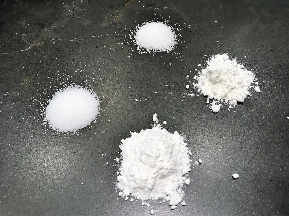 4 weiße Pulver auf schwarzem Hintergrund