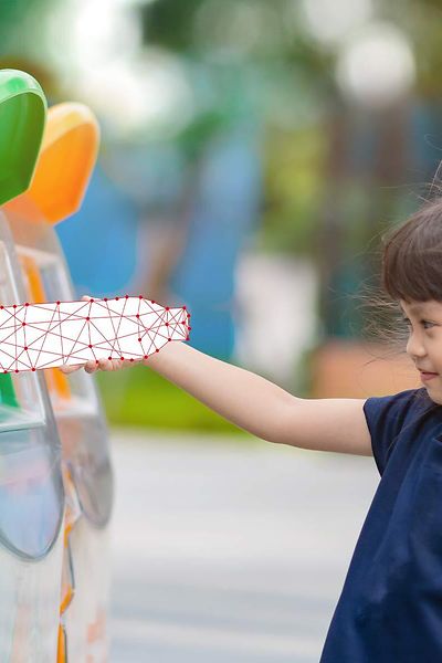 Girl-putting-bottle-in-recycling-grid