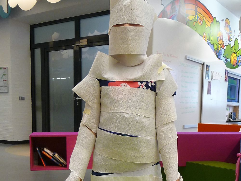 upper body of child wraped in toilet paper