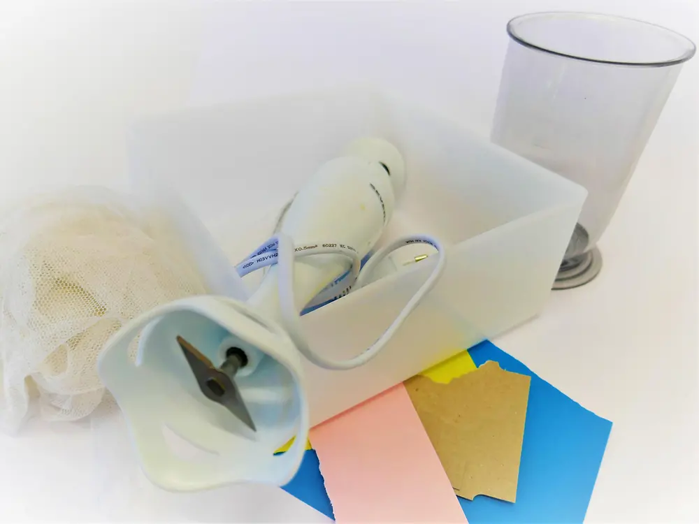 papel, liquidificador, jarro medidor, tigela de plástico e peneira