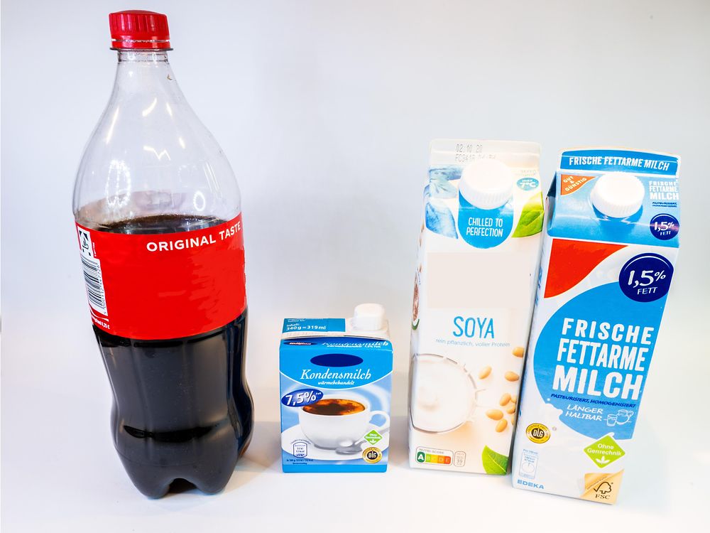 bottle with cola and three containers with milk
