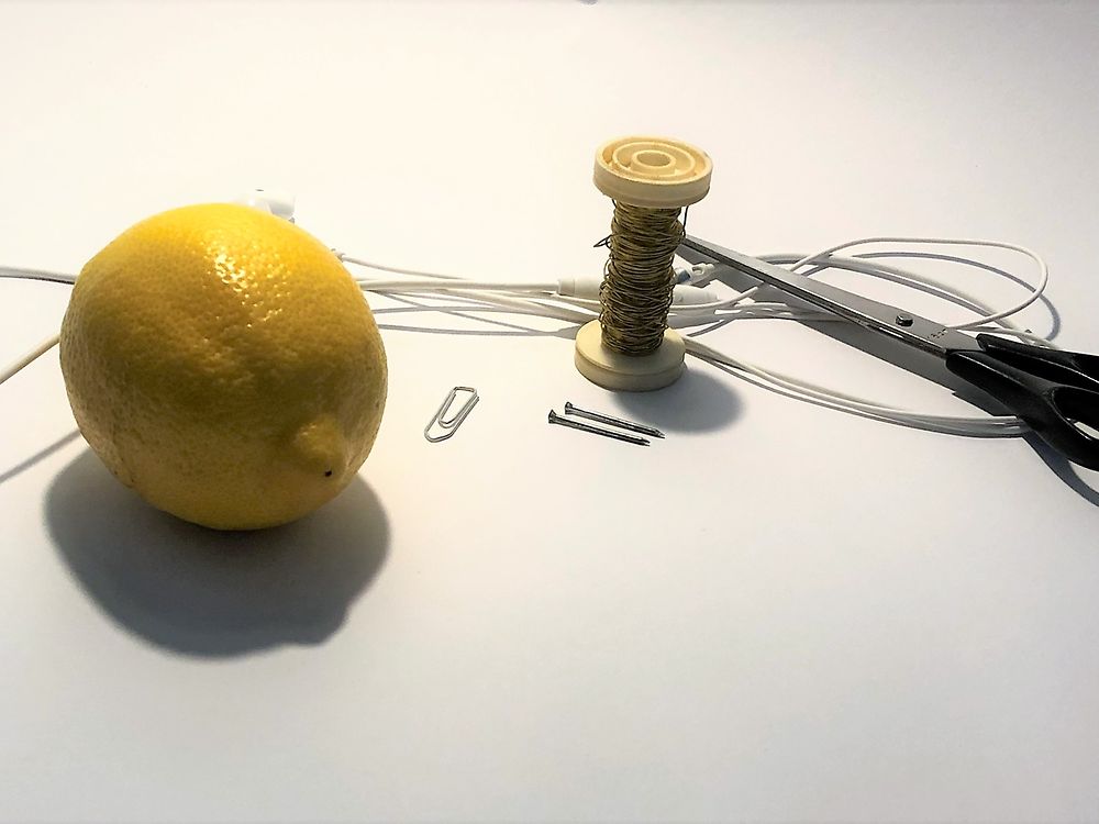 Eine Zitrone, Nägel, Büroklammer, Schere und Kopfhörer