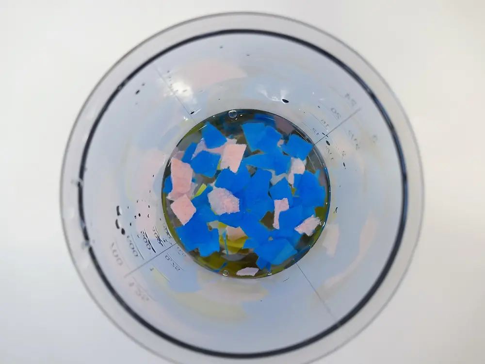 guarda dall'alto in una brocca di plastica contenente pezzi di carta colorati