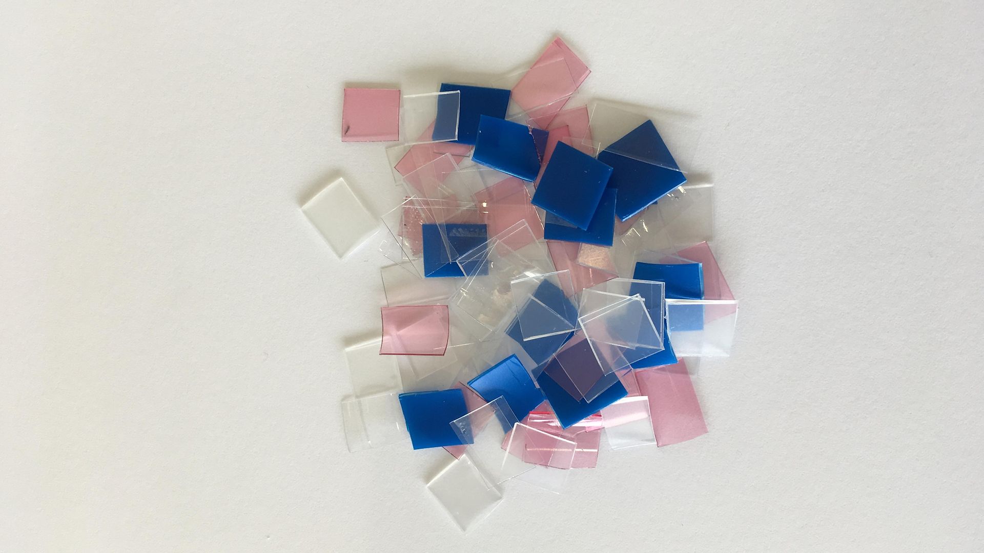 маленькие голубые, розово-белые и прозрачные пластиковые вырезки