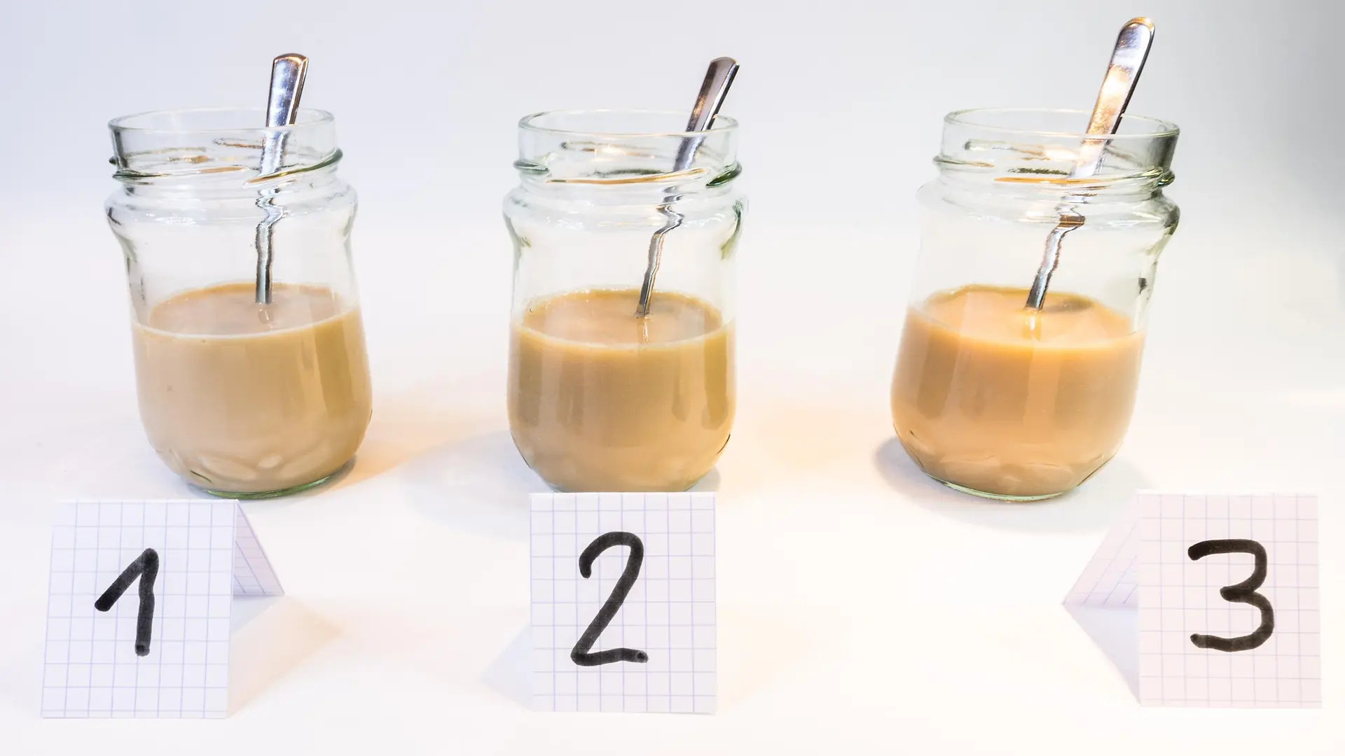 three glass jars with light brown milky liquids