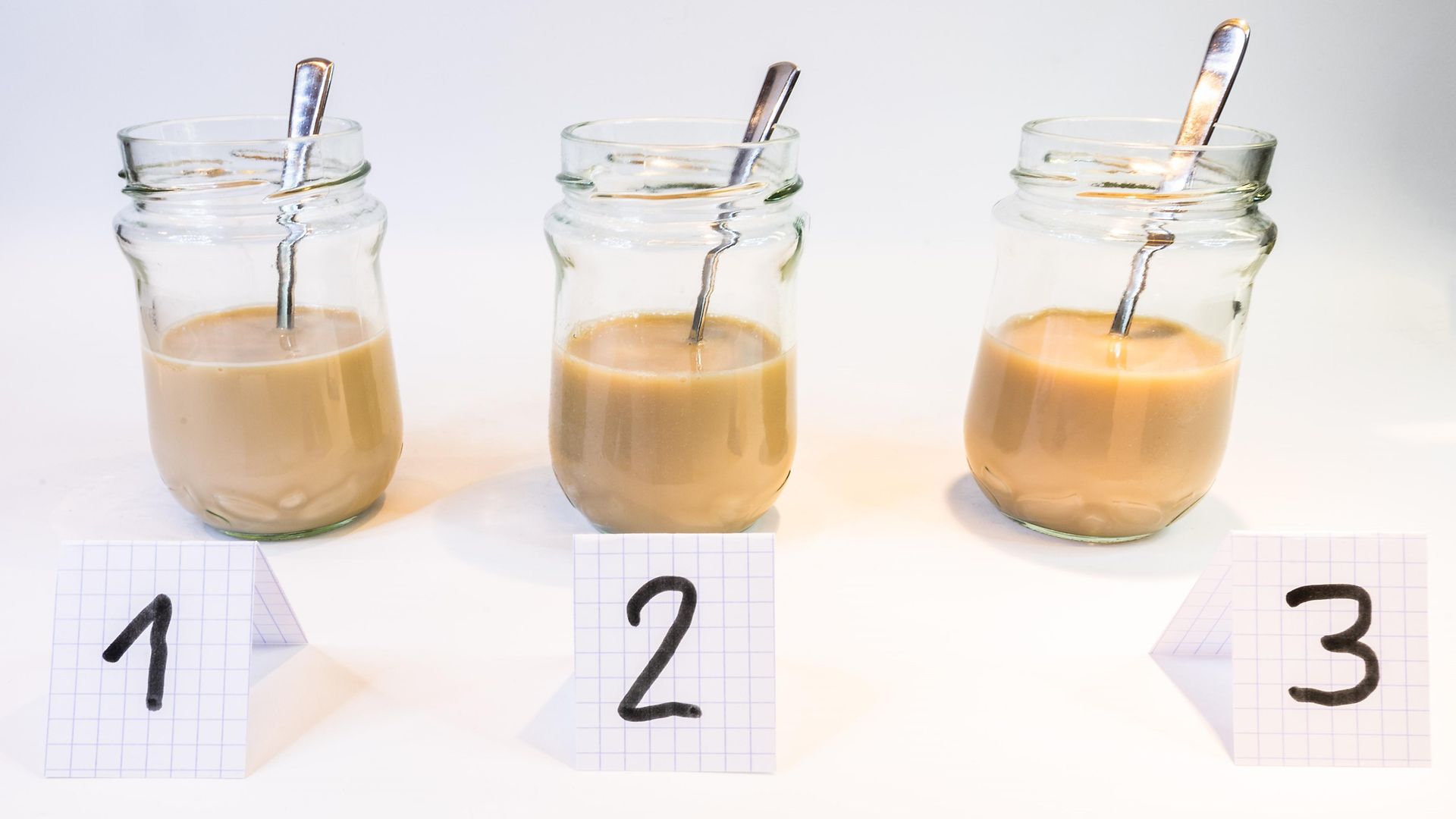three glass jars with light brown milky liquids