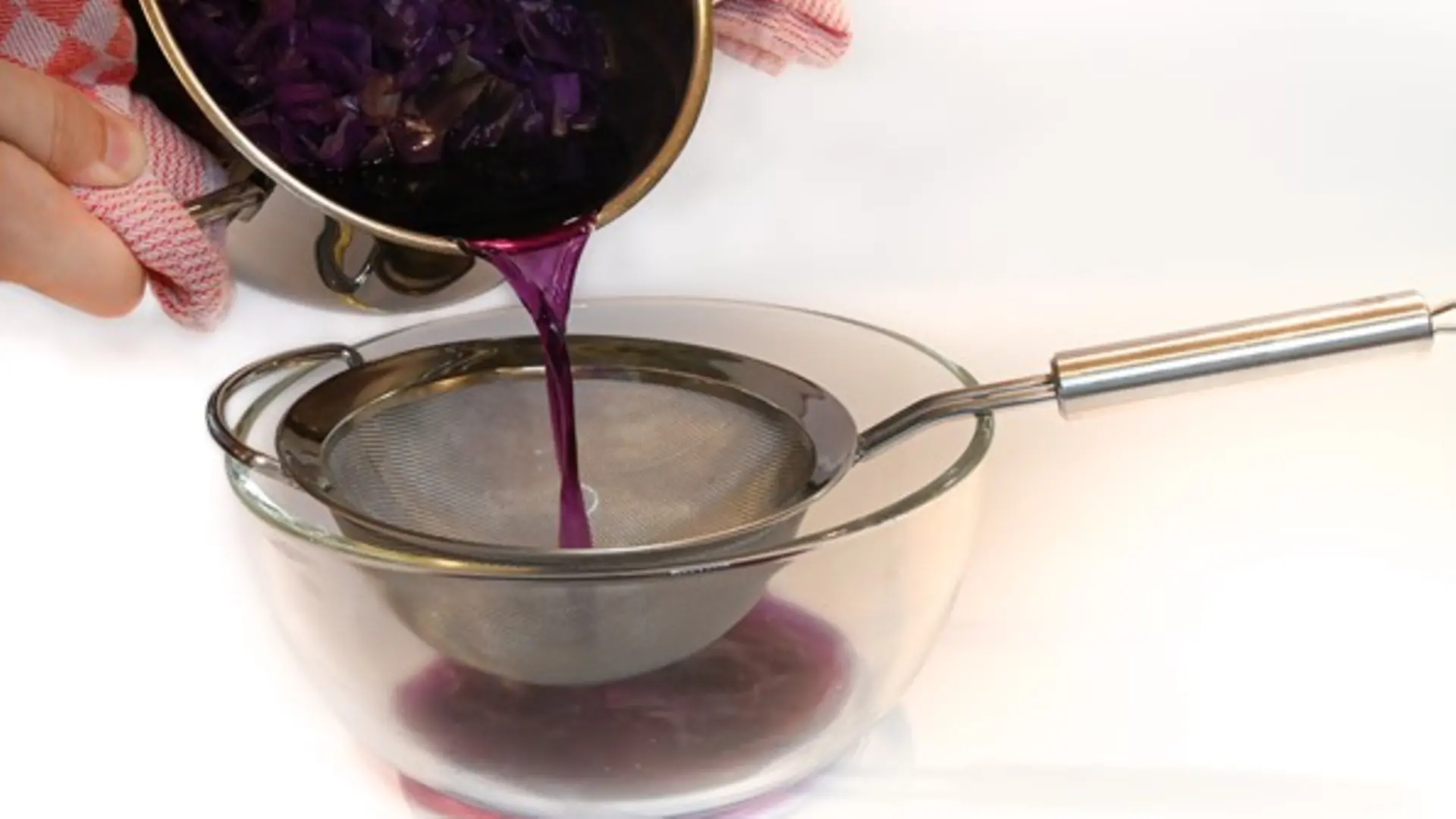 Rotkohl-Wasser-Mischung wird über Sieb ausgekippt