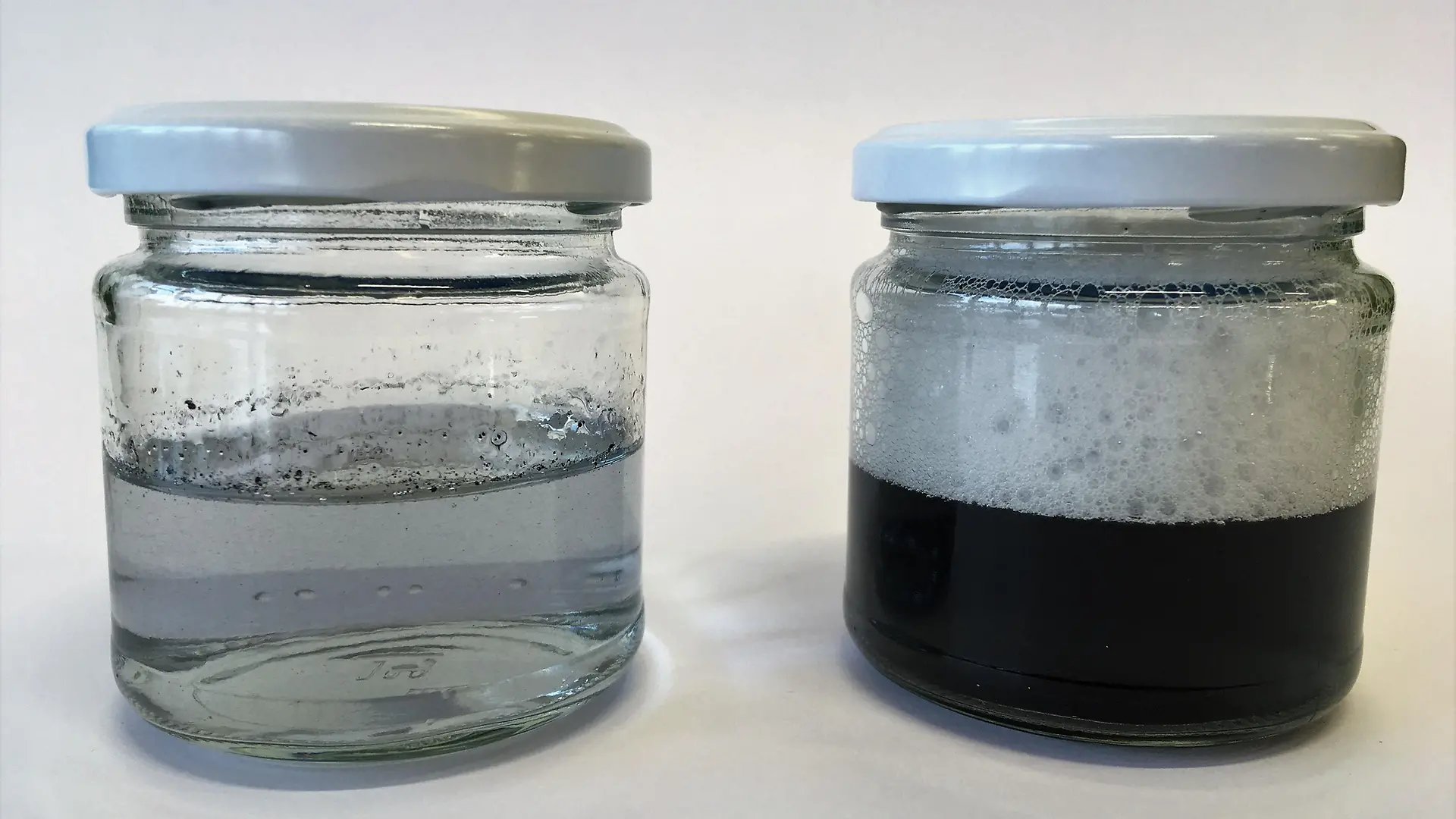 dois frascos de vidro com fuligem em água e espuma