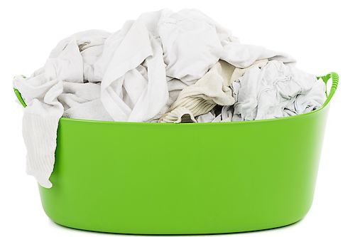 grüner Korb mit weißer Wäsche