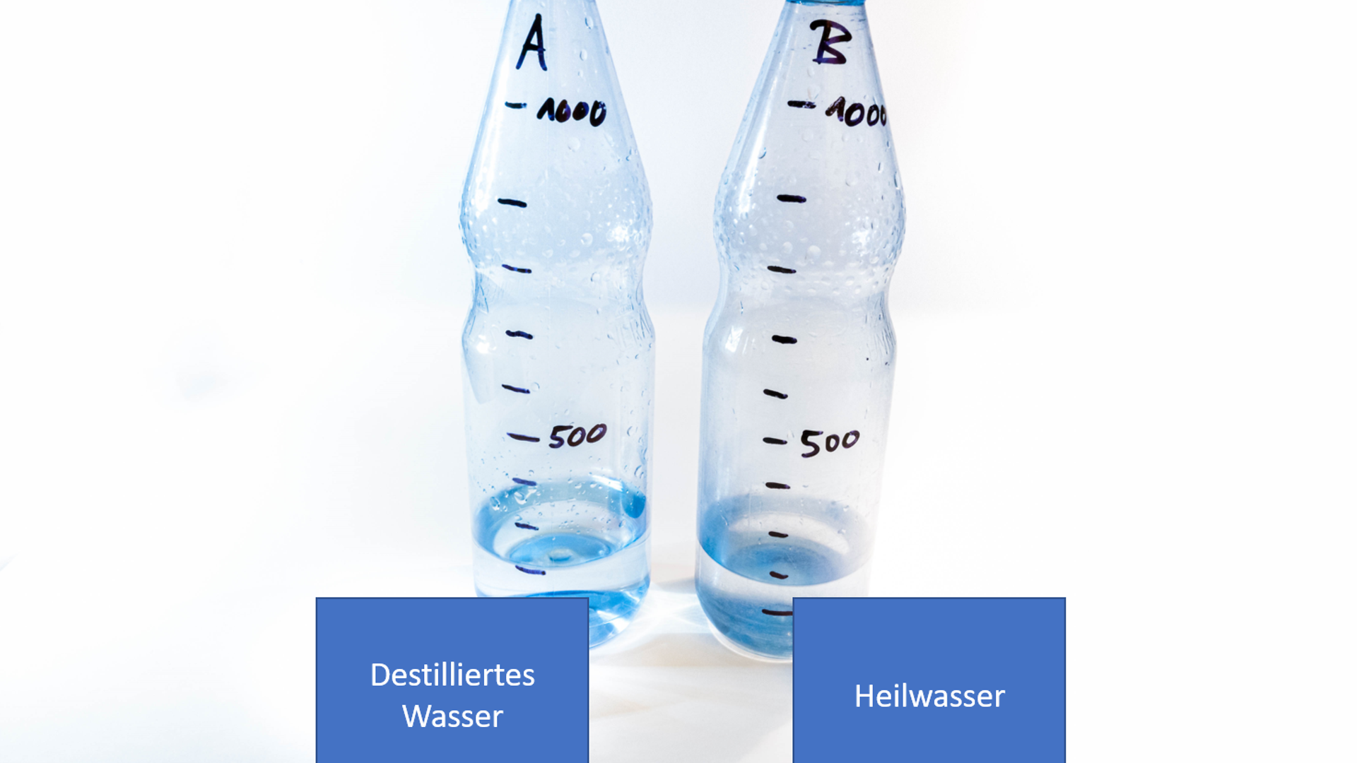 two plastic bottles with water samples: Distilled water and tap water