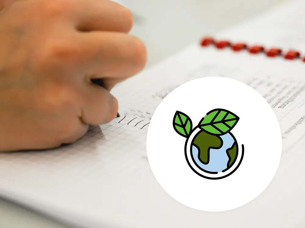 símbolo de sustentabilidade terra na frente de uma imagem com uma mão escrevendo em um livreto