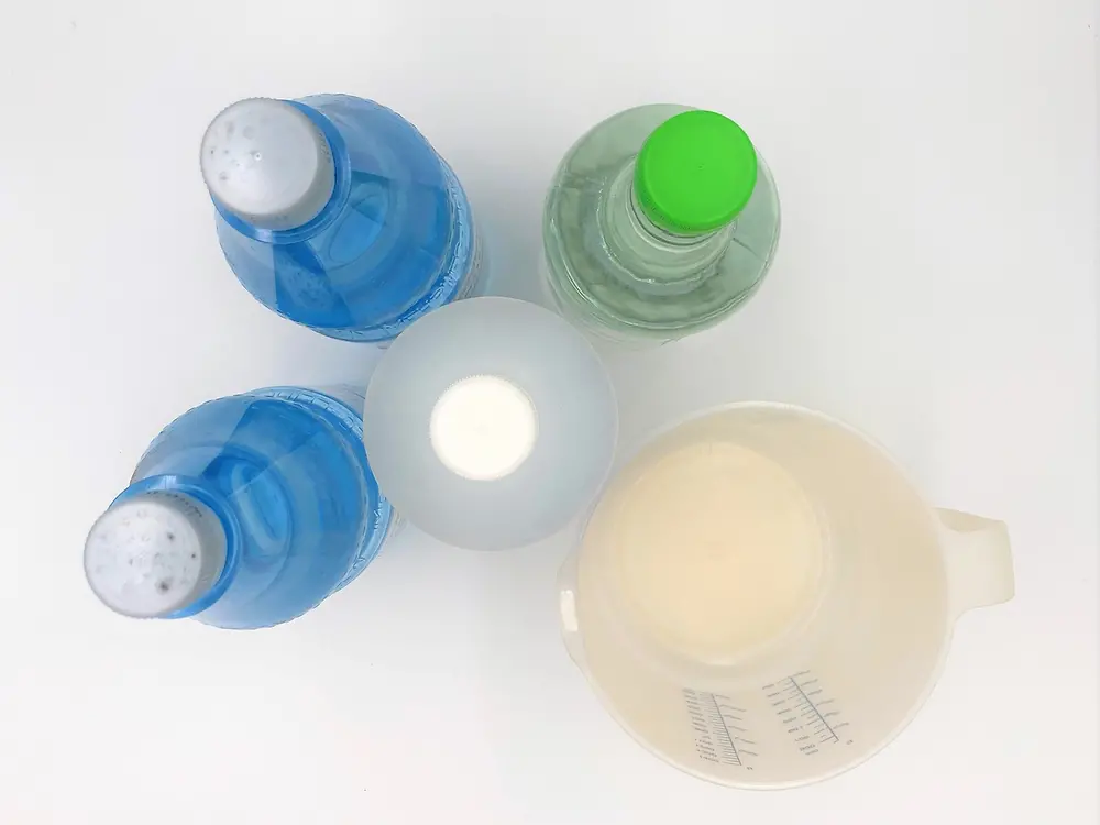 yukarıdan resim: dört plastik şişe ve ölçü kabı