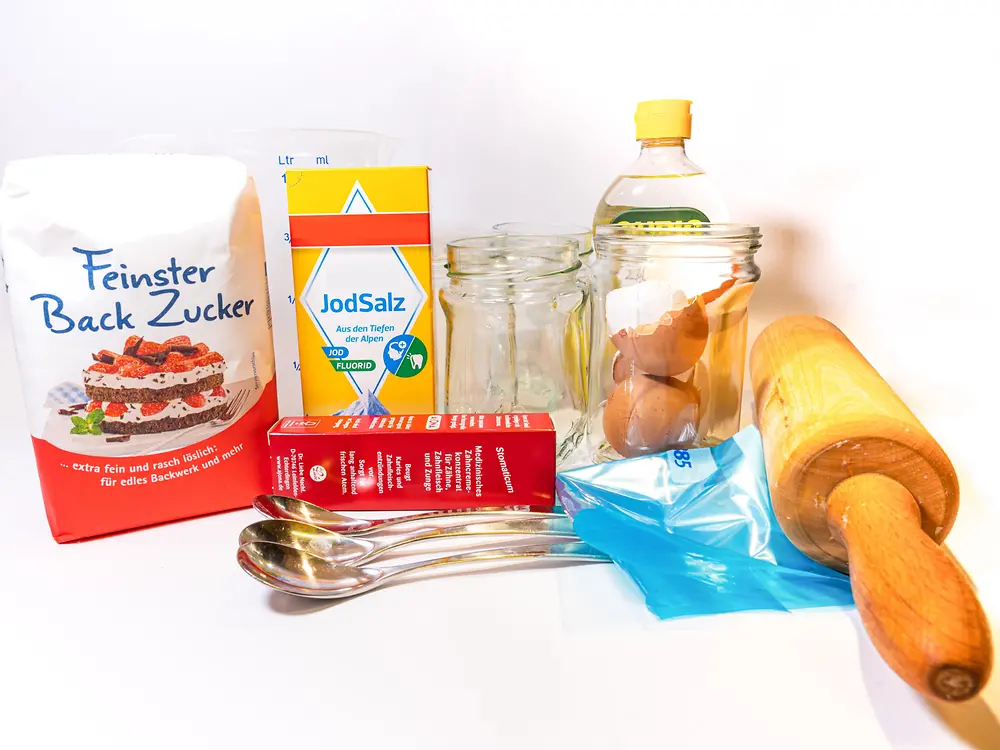 Zucker, Salz, Eierschalen, wässrige Zitronensäure, Gläser, Gefrierbeutel, Löffel und Nudelholz