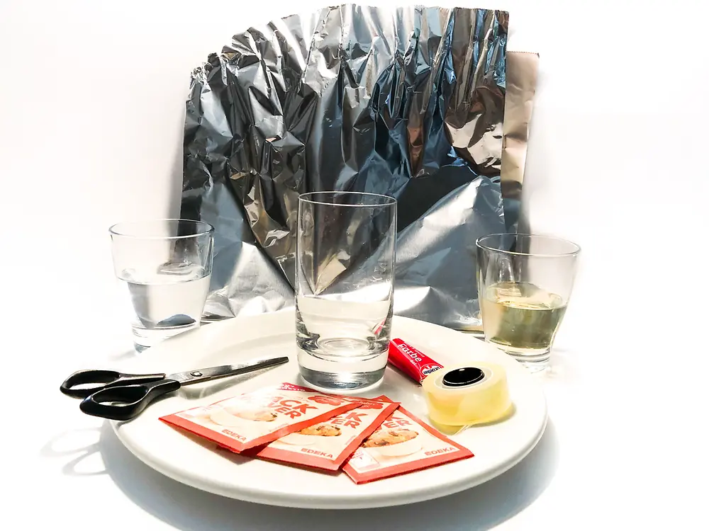 prato com pacotes de fermento em pó, tesoura, copos na frente da folha de alumínio