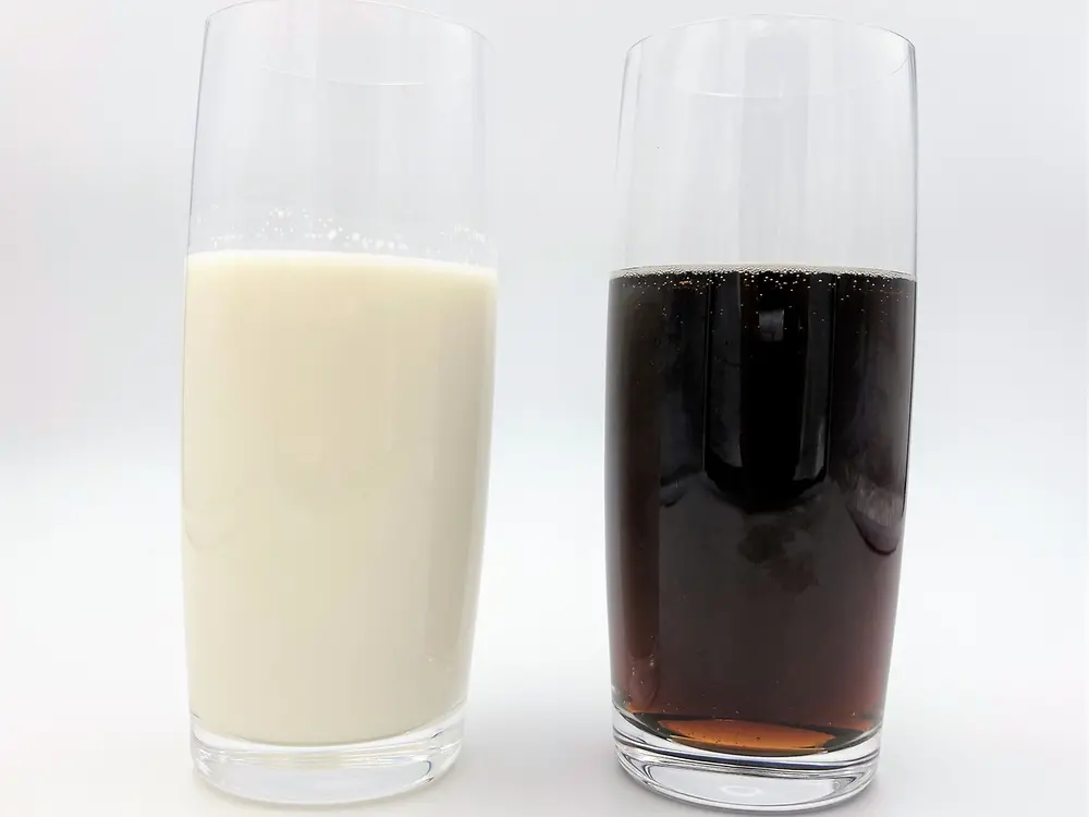 glass with milk besides glass with cola