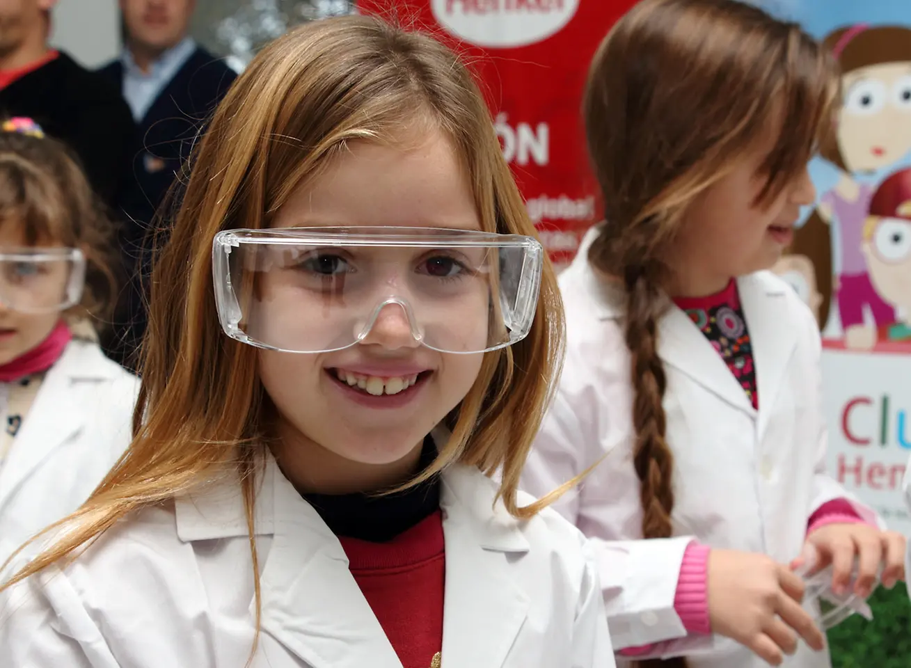 Club Henkel Mundo de Pesquisadores América latina: Menina com óculos de segurança grandes rindo da câmera.