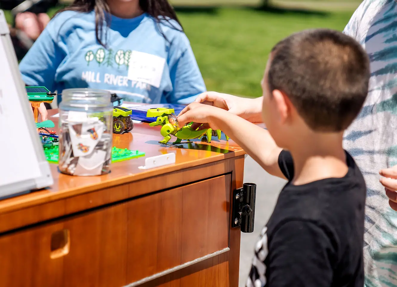 Student plays with a mechanical dinosaur toy.
