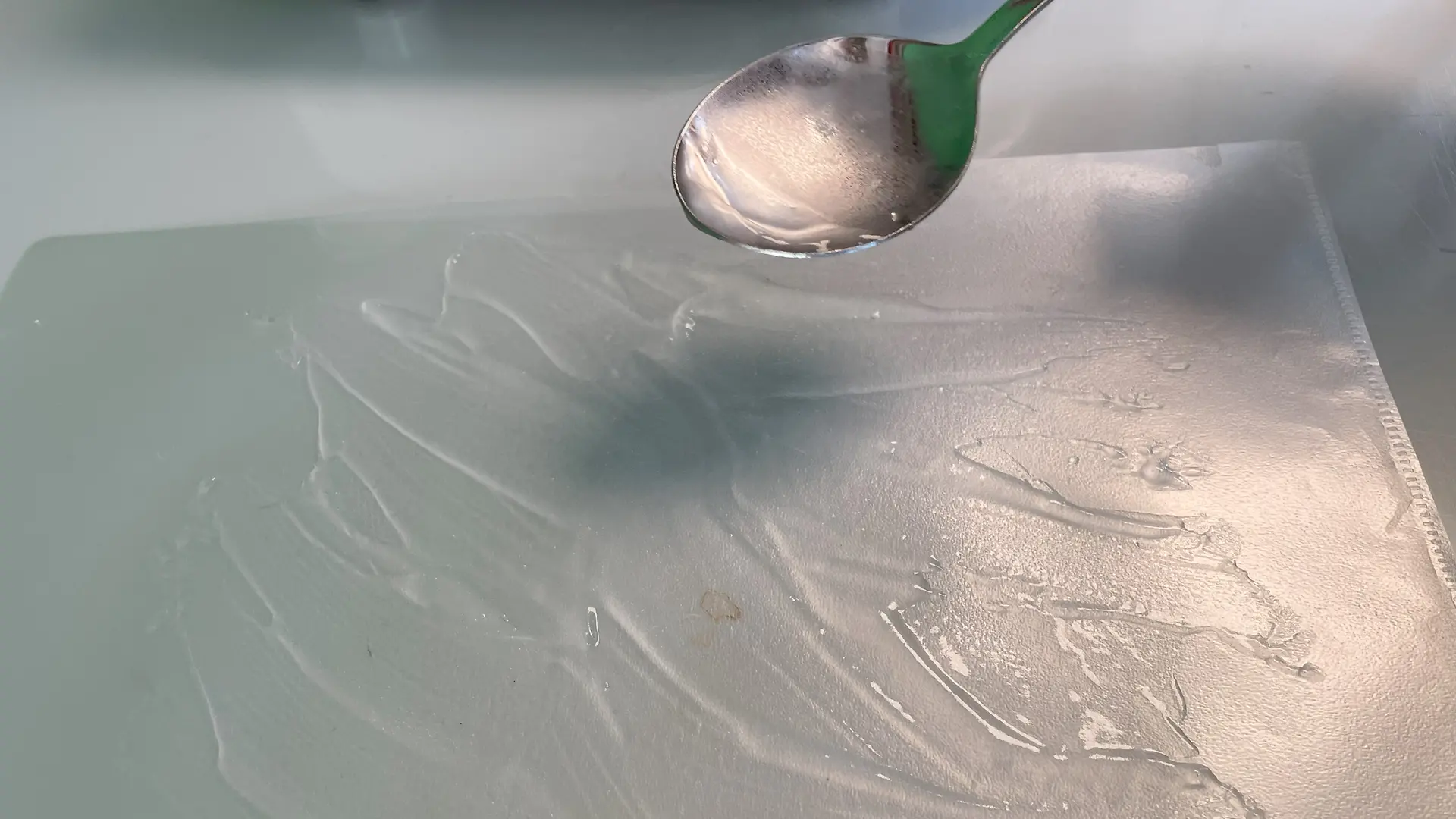 Löffel mit gelartiger Masser wird über eine Folie gehalten, auf der das Gel verstrichen wurde.