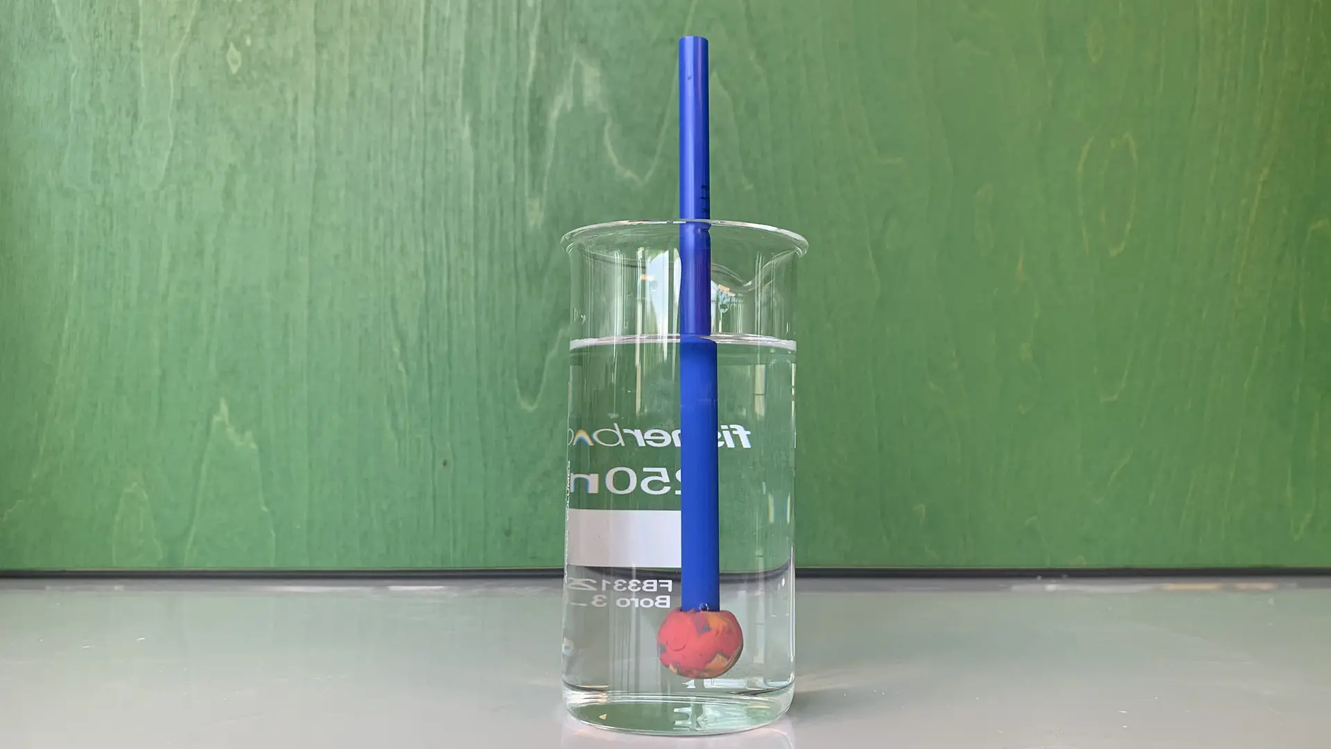 Ein Glas Wasser mit einem „Forschungstaucher“. Ein Taucher schwimmt aufrecht in einem Glas. 